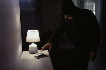 Robber in the hood inside the house at night  