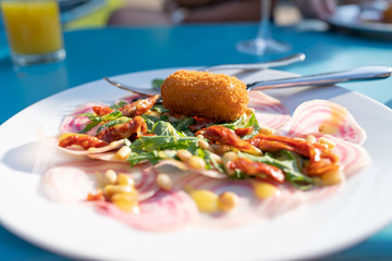 A white plate with a starter of croquette and salad typical Dutch fried food in culinary style