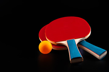 Red ping pong racket on dark background. Sports equipment