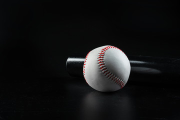 Baseball game equipment on dark black background close up