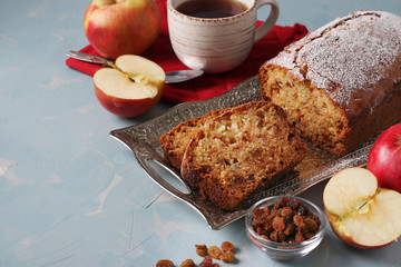 Homemade muffin with semolina, apples and raisins on a metal tray on a light blue background, Copy space