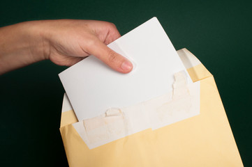 Hand that open a letter from brown envelope