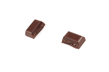 Close-up pieces of chocolate bar with filling isolated on white background.