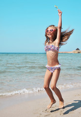 Obraz na płótnie Canvas Cute girl has fun on the beach. Summer time.