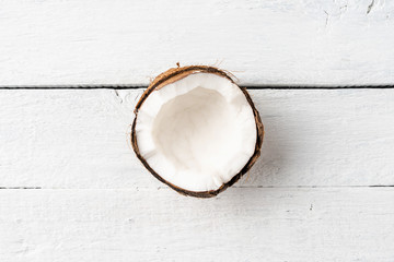 Half of fresh coconut on white wooden background. Top view