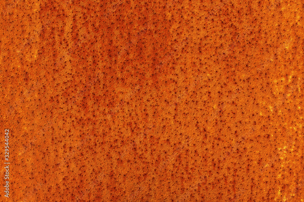 Wall mural the surface of an old rusty sheet of metal with small dots. abstract modern trendy red rusty texture