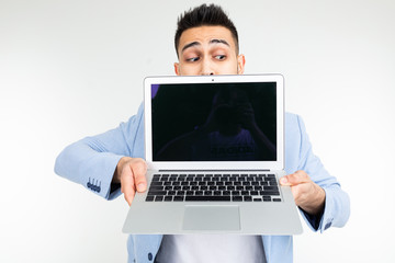 stylish successful man in a jacket demonstrates a laptop screen with space for advertising on a white studio background