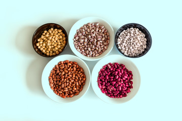 Phaseolus. Bright multi-colored beans, mung beans and chickpeas in ceramic cups. A complete source of vegetable protein in vegetarianism. The concept is healthy eating.