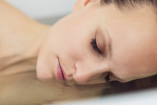 Frau liegend im Wasser Portrait mit geschlossenen Augen