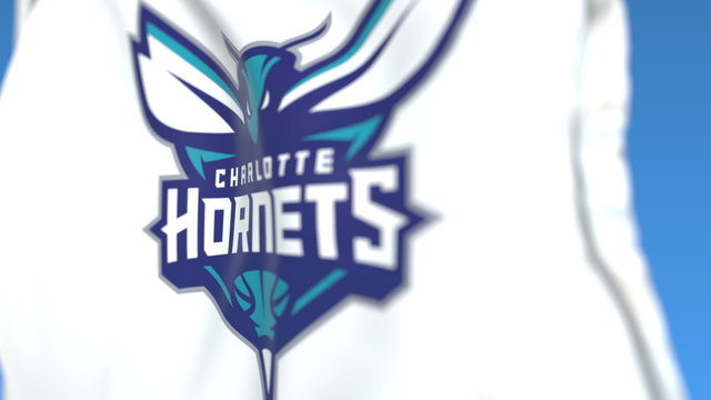 Flying flag with Charlotte Hornets team logo, close-up. Editorial 3D rendering
