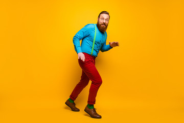 Fototapeta na wymiar Full length body size view of his he nice attractive cheerful cheery funky guy sneaking walking tiptoe isolated over bright vivid shine vibrant yellow color background