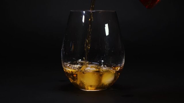gold whiskey poured into an empty glass