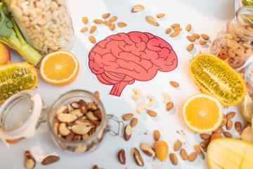 Human brain drawing with variety of healthy fresh fruits and vegetables on the table. Concept of...