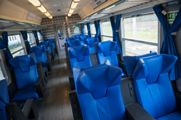 Deserted carriage of an inter-urban train with empty blue seats traveling in Rome, Italy