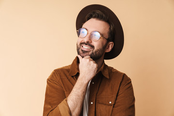 Happy young unshaved man in hat isolated