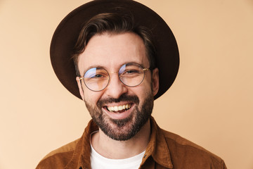 Happy young unshaved man in hat isolated