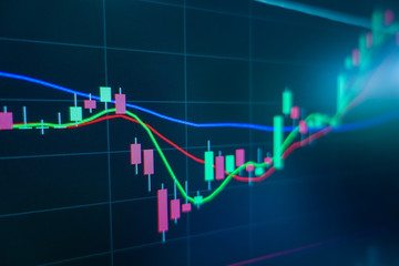 Stock market trading graph and candlestick chart on screen monitor for financial investment and economic concept.