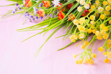 Wild flowers on a wooden pink table background