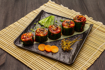 Korean style stuffed cucumbers. Kojori kimchi spicy snack. Fermented and marinated vegetables. Wooden background
