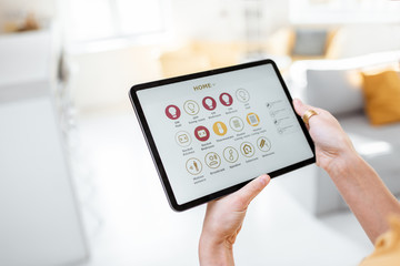 Controlling smart home devices using a digital tablet with launched application. Smart home concept
