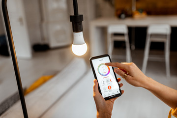 Controlling light bulb temperature and intensity with a smartphone application. Concept of a smart...