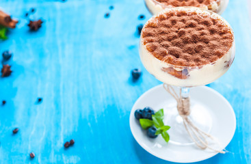 luxury tiramisu dessert in a cocktail glass decorated with cocoa