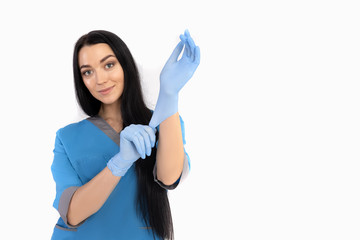 Woman doctor in blue uniform puts on gloves