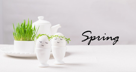 Festive composition Easter eggs with eyes in a white bowl yellow tulips flowers on the table text Spring
