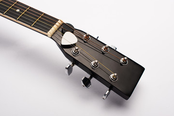 Close up view of guitar picks under strings on white background