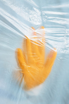 Close up of woman's hand in glove behind curtain in quarantine
