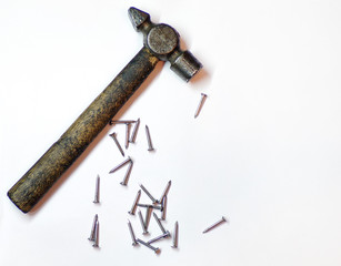 Nails and hammer isolated on white background close-up top view. Background of repair and construction .