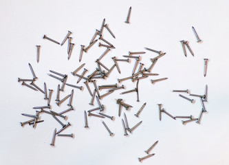 Lots of nails isolated on a white background top view. The concept of construction and repair . Small nails with a copy space.