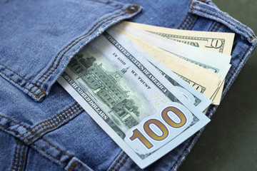 Banknotes of different denominations in the pocket of women's jeans, background. Concept, American...