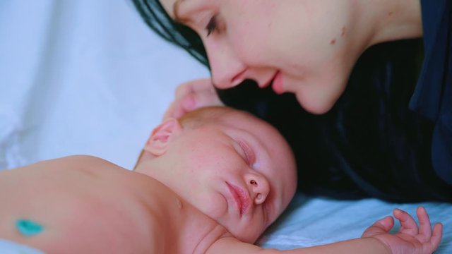 Close up of mother kissing sleeping baby. Maternity concept