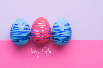 Three easter eggs on paper color background. Easter holiday concept.