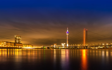 Fototapeta na wymiar Night view of Dusseldorf on the bank of Rhine in Germany; Rheinturm and skyscrapers
