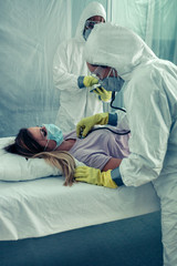 Doctors with bacteriological protection suits attending a patient