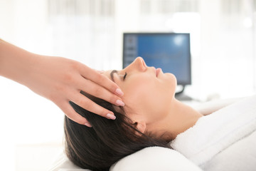 Fototapeta na wymiar Brunette woman feeling relaxed while having facial massage