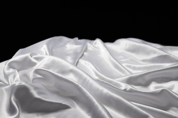 close up view of white soft and crumpled silk textured cloth isolated on black