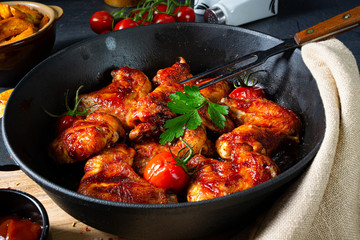 Spicy chicken wings in honey with potato wedges