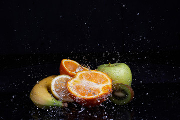 Fruits with water splash on black background