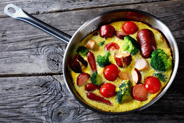 baked omelet or frittata with sausages, tomato