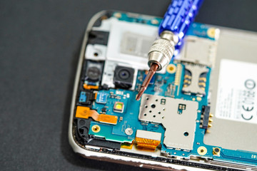 Technician repairing micro circuit main board of smartphone electronic technology : computer,...
