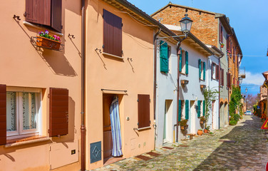 Fototapeta na wymiar Perspective of an old street with colorful houses italian town
