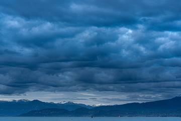 Dark sky from rain, storm, thunderstorm, lake and mountains