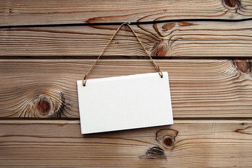 White cardboard signboard on  brown wooden background