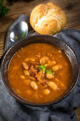 Beans with tomato sauce, bacon and sausage.