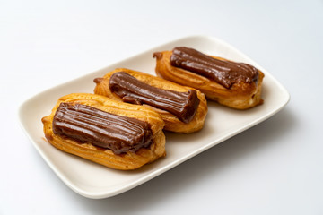 plate cakes chocolate icing on white background