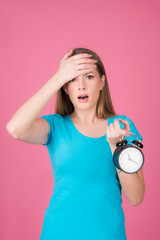 pressurized girl , getting late concept, with  retro clock, isolated on pink background