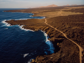 Aerial view of lava cliffs and ocean with sunset. Lanzarote, Canary Islands.